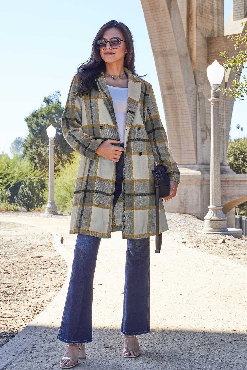 Woman wearing full-size plaid button-up lapel collar coat outdoors, stylish autumn fashion look.