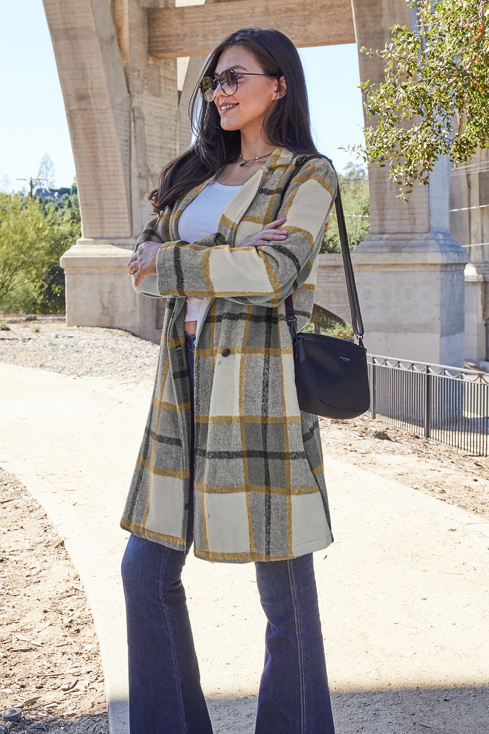 Woman wearing full size plaid button up lapel collar coat with pockets, outdoor setting