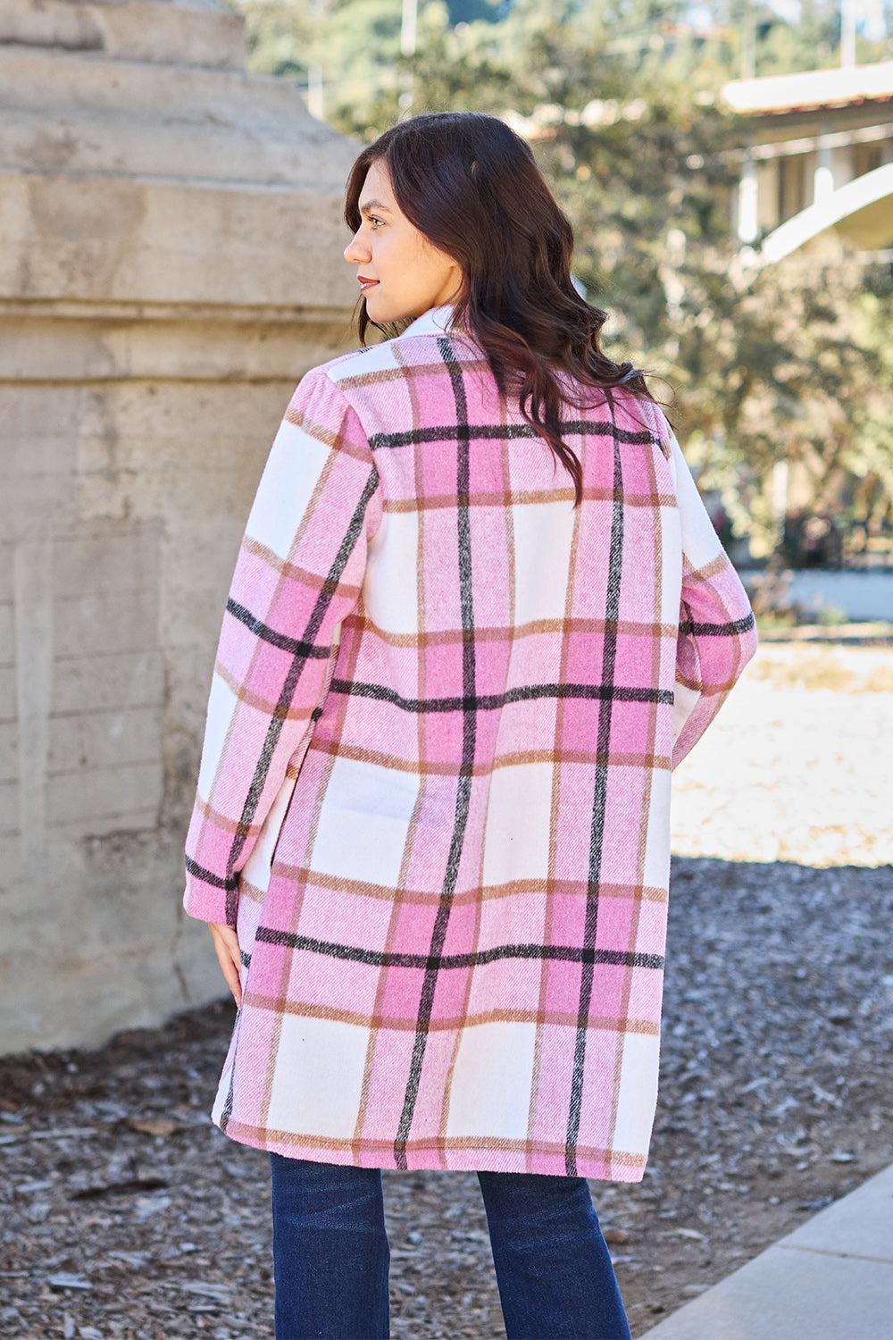 Woman wearing full size plaid button up lapel collar coat with pockets, pink and white pattern, made of 100% polyester.