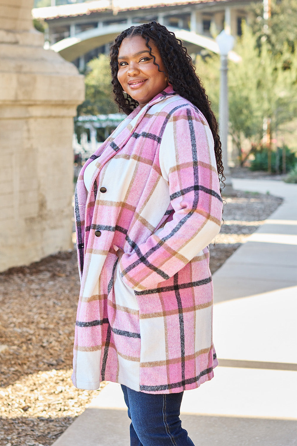 Woman wearing a full-size plaid button-up lapel collar coat with pockets and pink, white, and black stripes, made of 100% polyester.