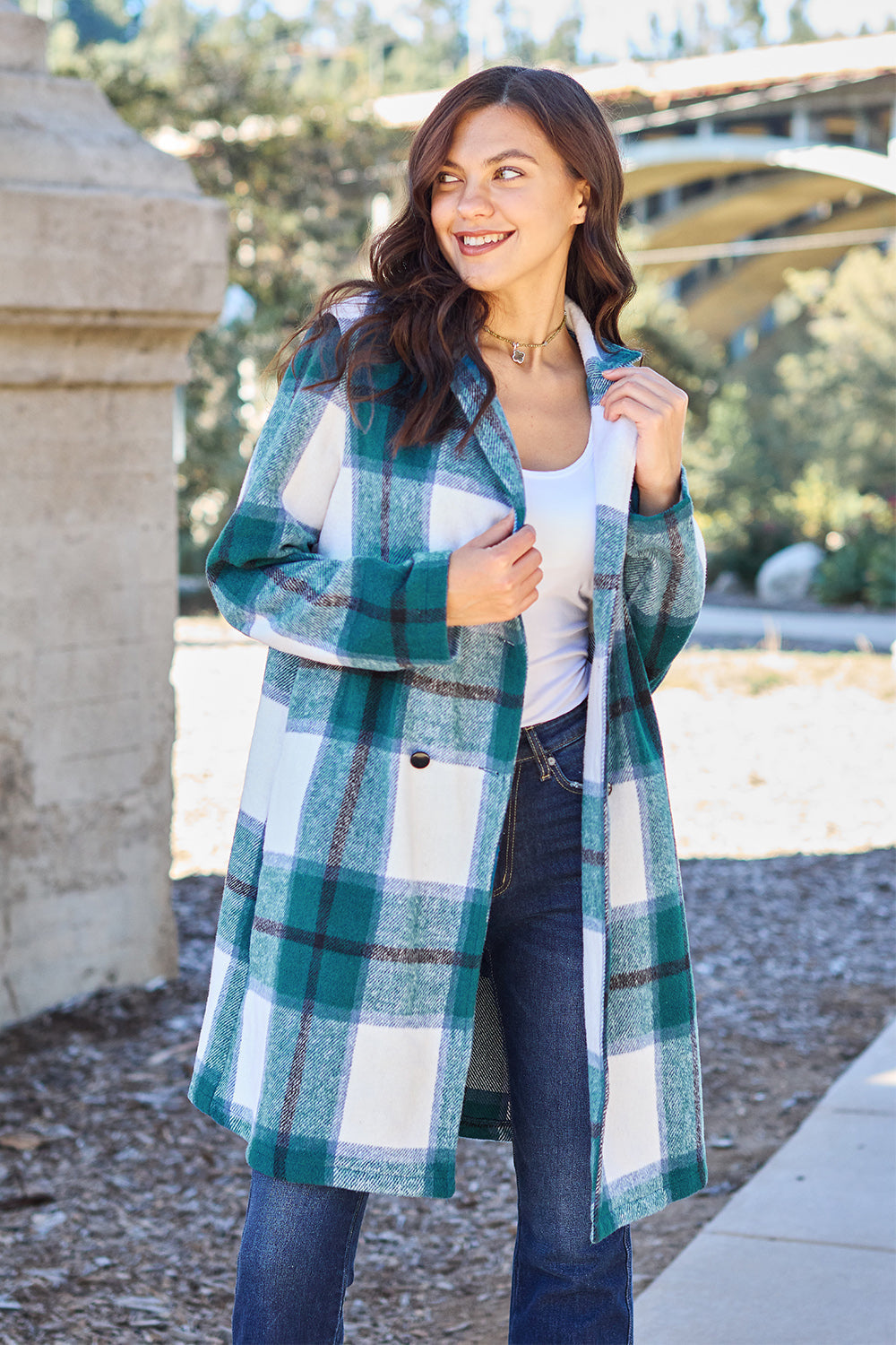 Woman wearing full-size plaid button-up lapel collar coat with pockets, made of 100% polyester, outdoors.