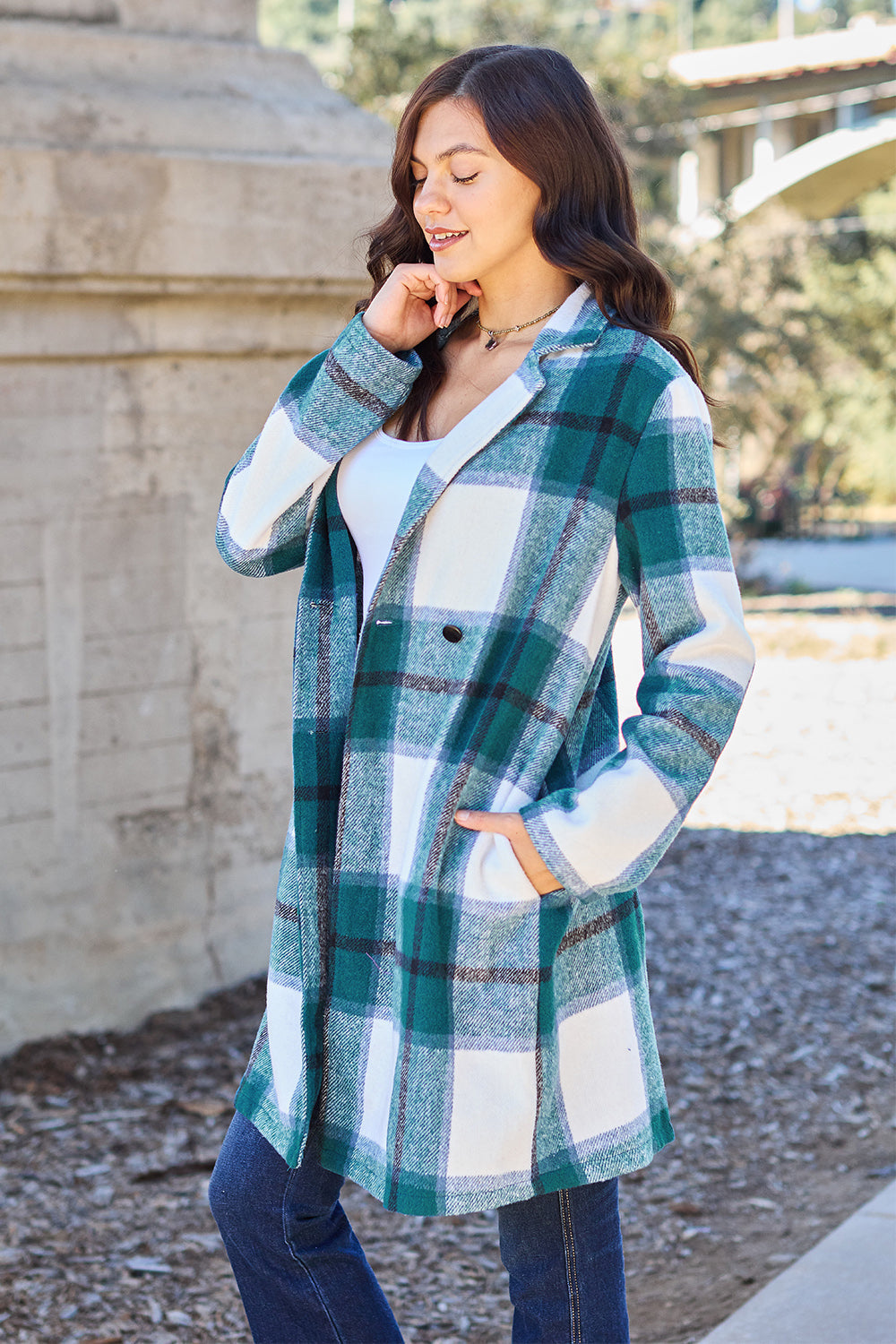 Woman wearing a full-size plaid button-up lapel collar coat with pockets, made of 100% polyester, ideal for casual outings