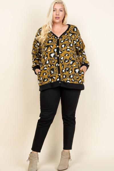 Plus size mustard animal print button-up cardigan with side pockets, modeled with black pants and ankle boots.