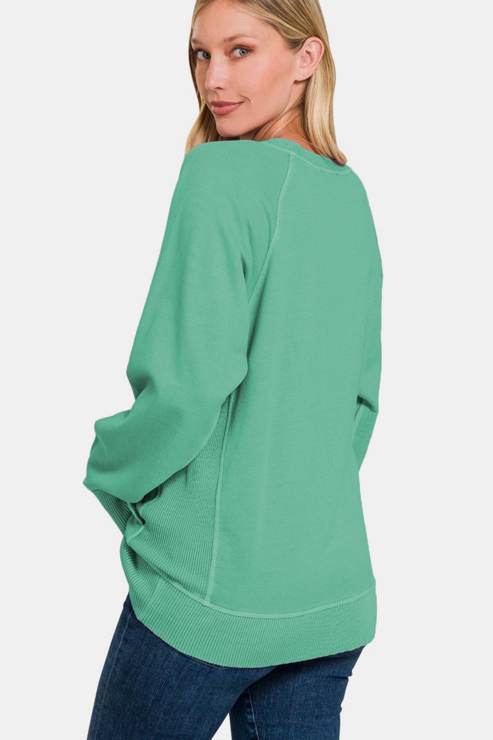 Woman wearing green pocketed round neck long sleeve sweatshirt made of 100% cotton, styled with casual jeans.