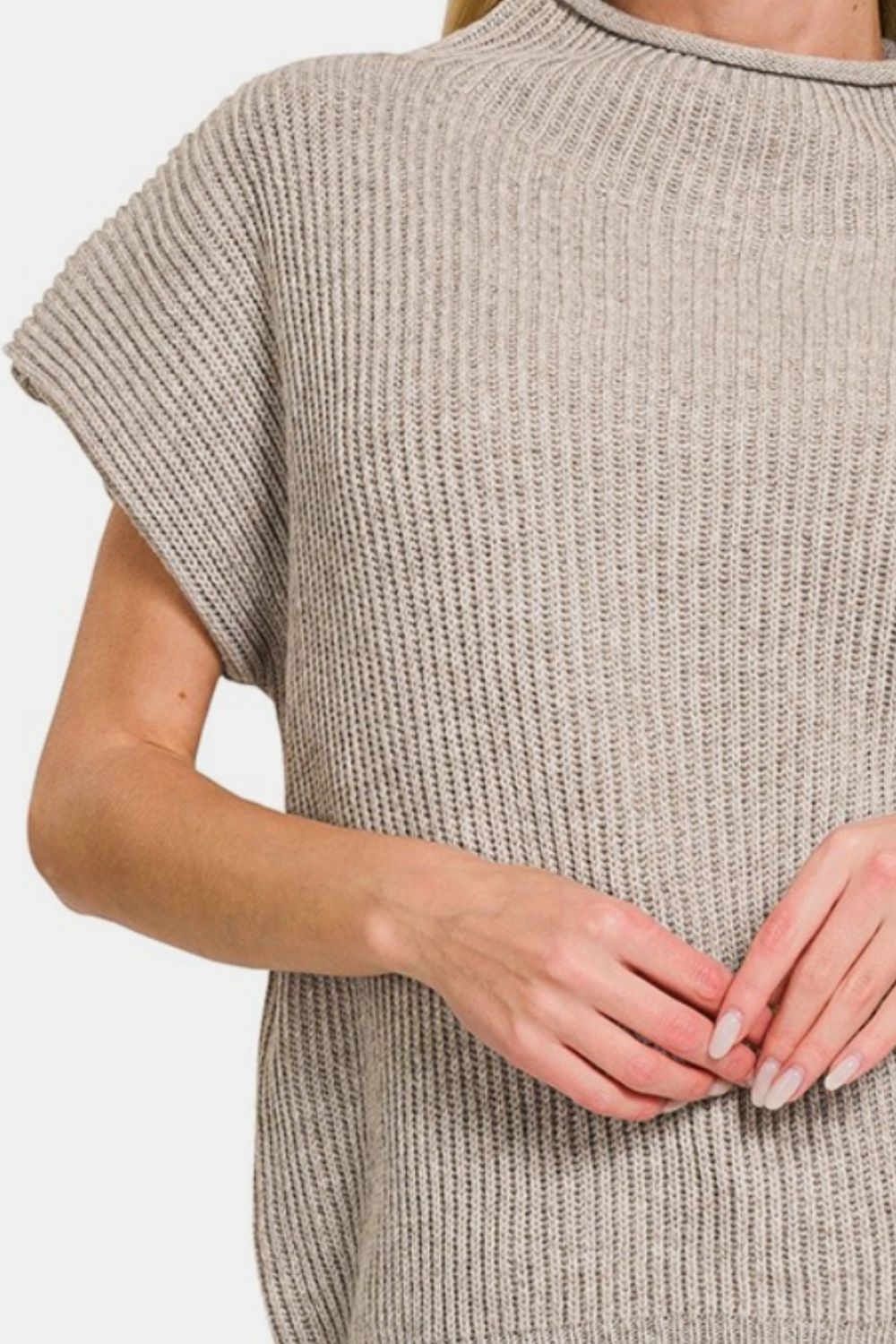 Woman wearing beige short sleeve mock neck sweater with ribbed texture, made from 50% polyester and 50% acrylic.