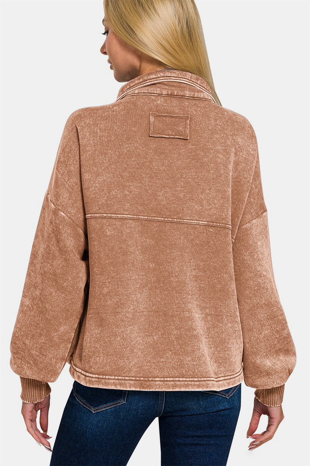 Woman wearing a brown wash fleece front pocket button up shacket made of cotton and polyester blend, showcasing the back view.