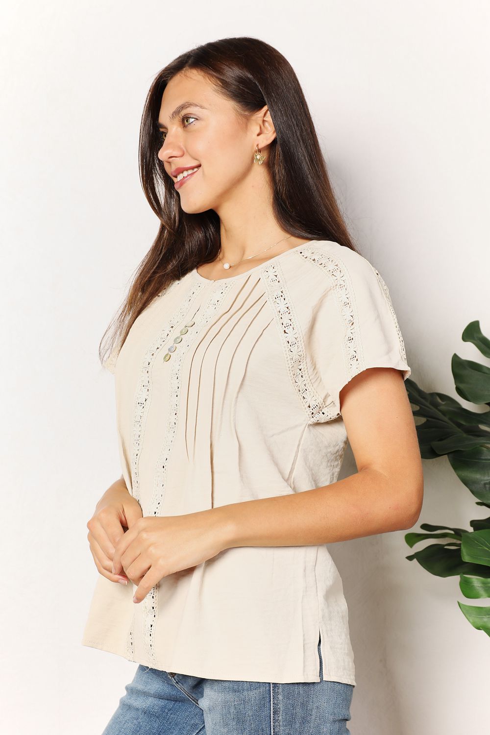 Woman wearing a chic crochet buttoned short sleeves top with a round neckline, styled for a casual look.