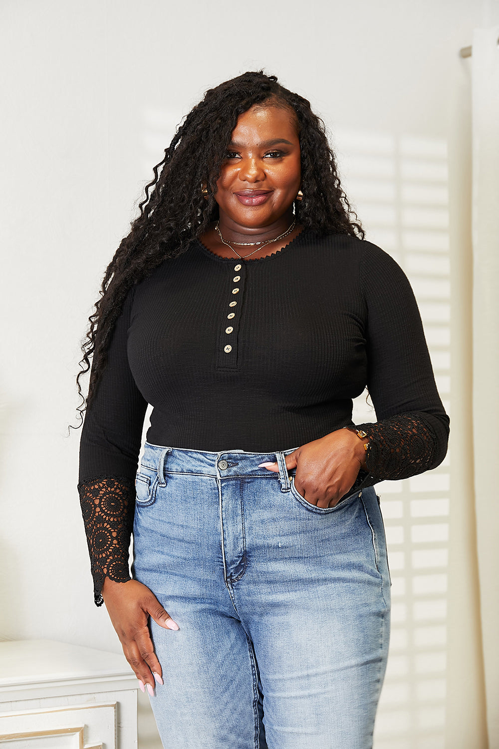 Woman wearing a black crochet lace hem sleeve button top with jeans, showcasing a comfortable, stylish fit.