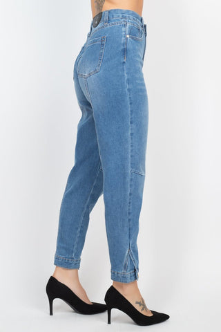 High-rise waisted medium denim mom jeans with cuffed-button hem worn with black heels.
