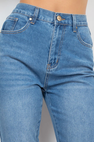 High-rise medium denim mom jeans with zip-fly button and five-pocket design featuring a cuffed-button hem detail.