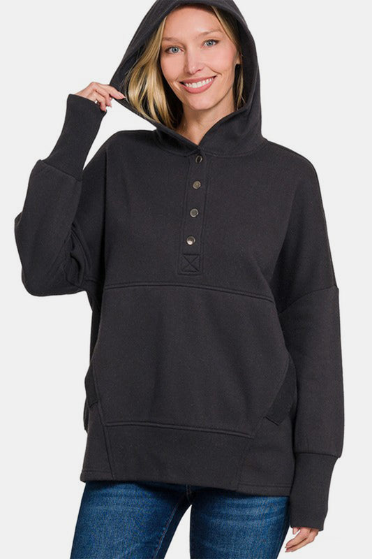 Woman wearing Zenana Half Snap Long Sleeve Hoodie with kangaroo pocket, featuring a ribbed design and slightly stretchy material.