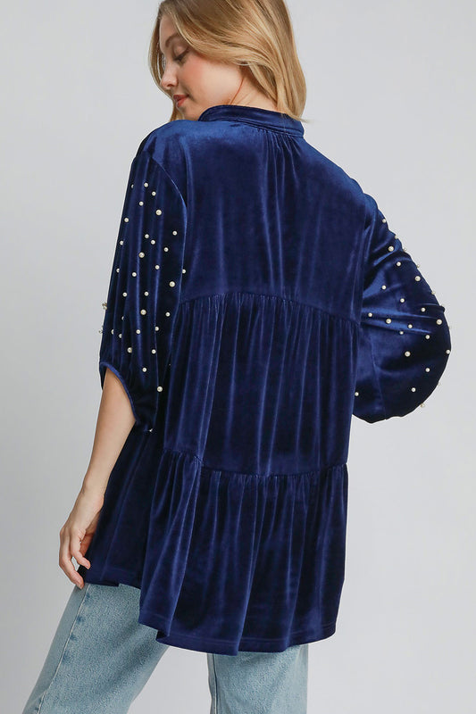 Navy velvet babydoll blouse with pearl details, collared neck, tiered design, and slightly stretchy fabric, back view.