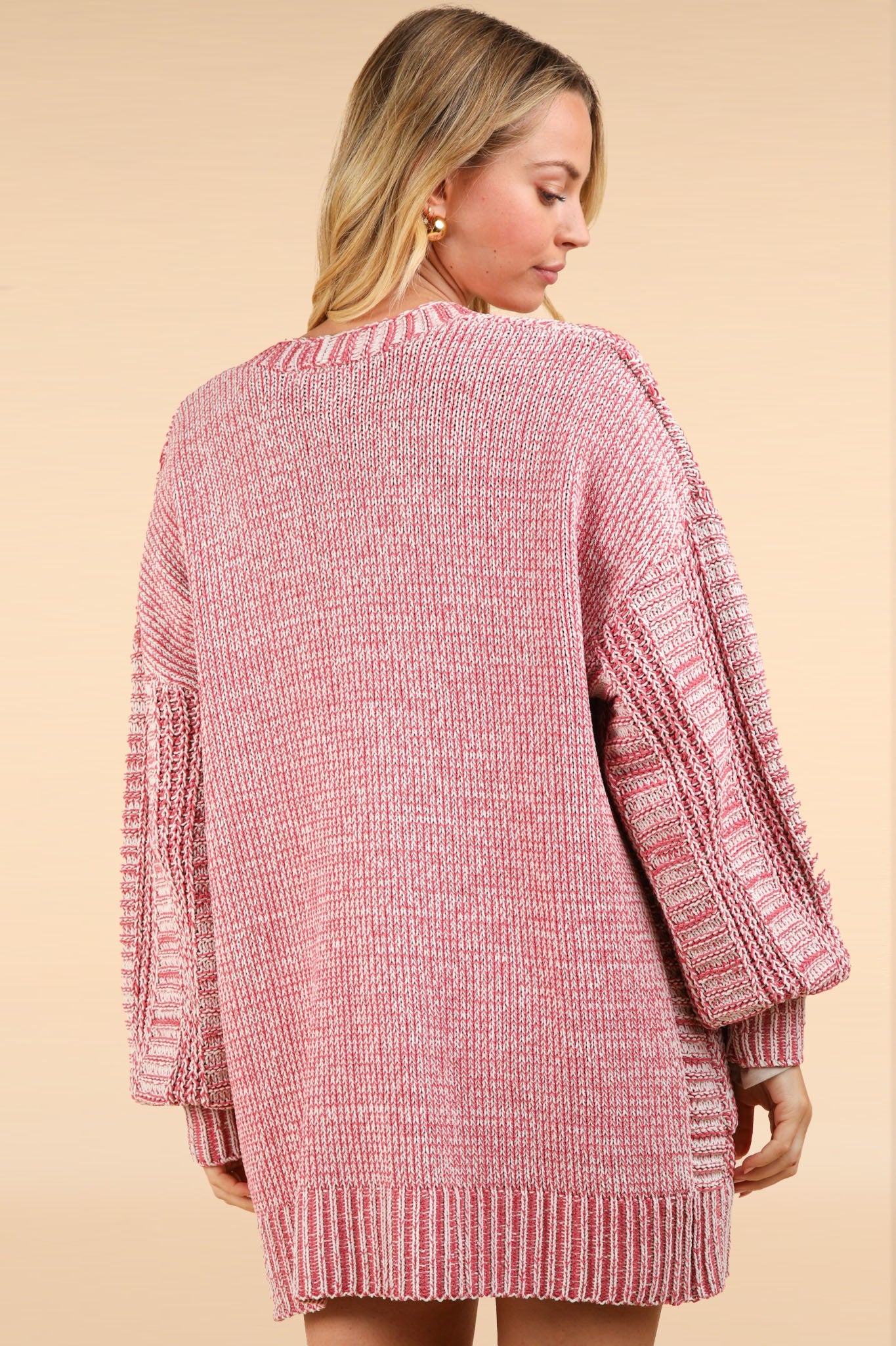 Woman wearing pink cable knit open front cardigan with a tweed design, perfect for spring, fall, and winter fashion.