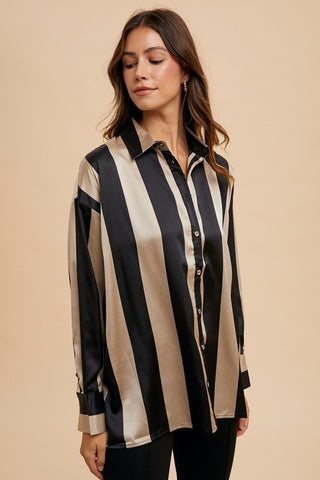 Woman wearing a striped dropped shoulder button-up shirt in black and beige, made of 100% polyester with no stretch.