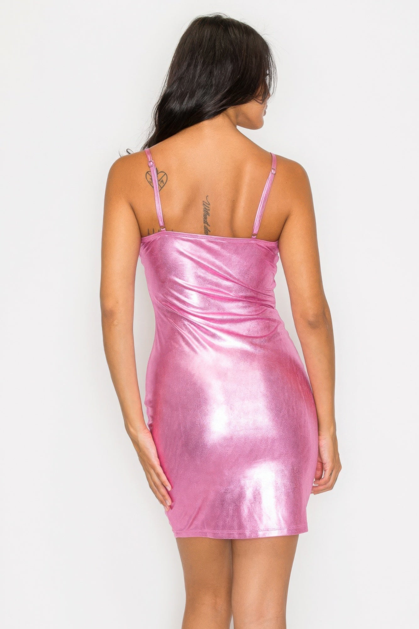 Woman wearing pink scoop neck foil mini dress with adjustable straps, showcasing bodycon fit and shimmering finish, back view.