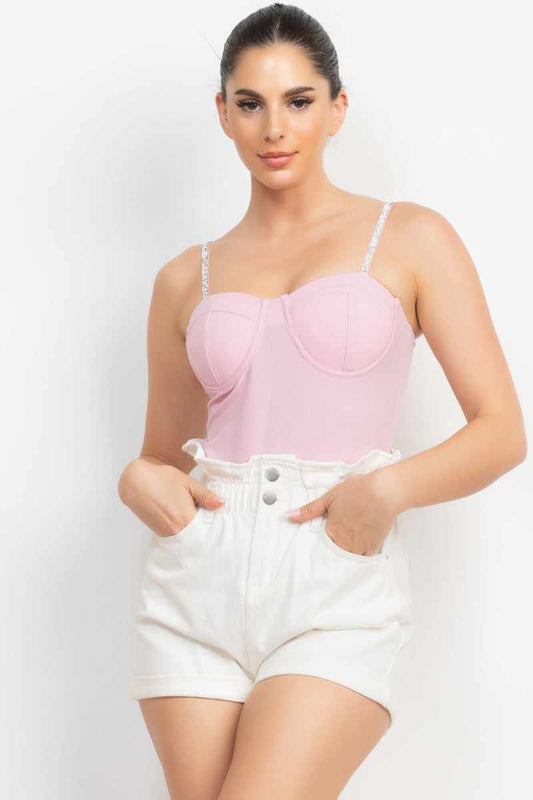 Pink rhinestone trim bustier cami bodysuit with sweetheart neckline and adjustable straps worn with white shorts.