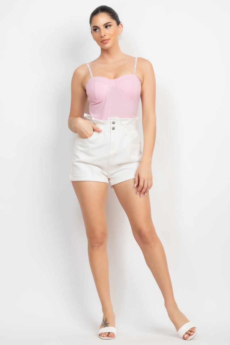 Woman wearing pink rhinestone trim bustier cami bodysuit with white shorts, featuring sweetheart neckline and adjustable straps.