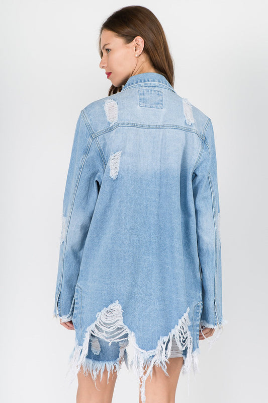 Woman wearing distressed frayed hem denim jacket with raw edges, highlighting edgy vintage-inspired style.