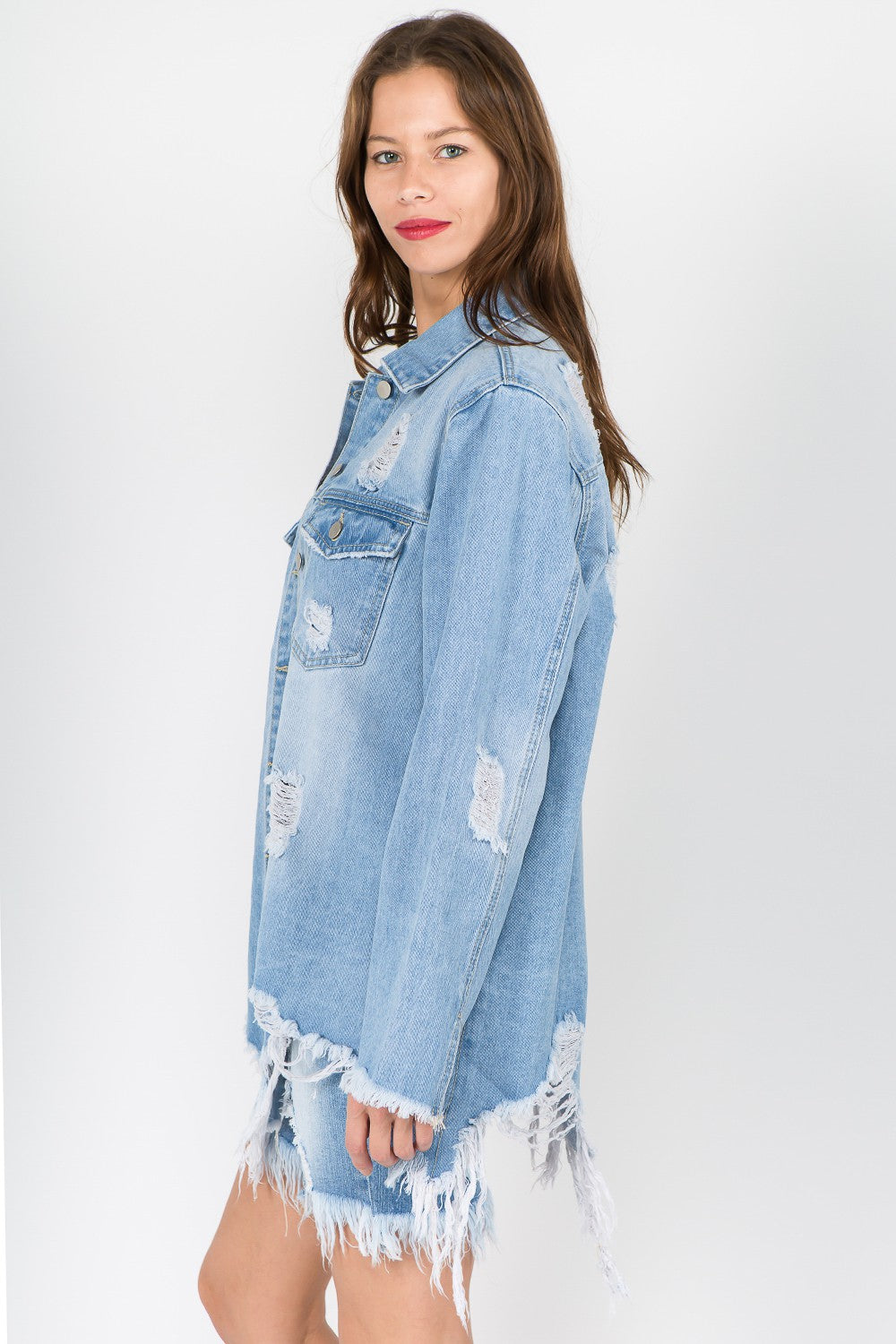 Woman wearing distressed frayed hem denim jacket with raw hem and vintage-inspired look