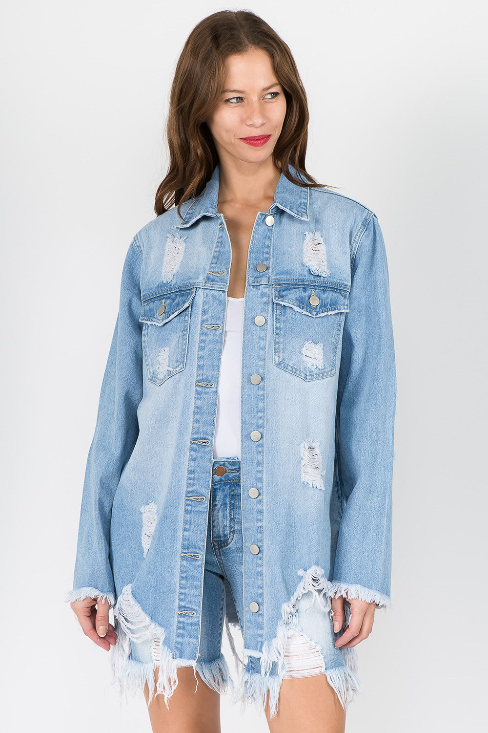 Woman wearing distressed frayed hem denim jacket with edgy raw hem and vintage-inspired look, perfect for casual outings.