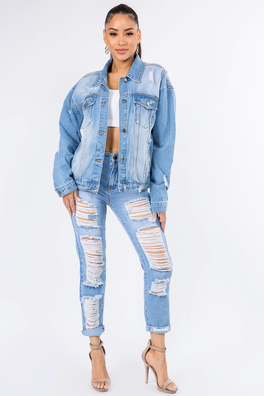 Graphic distressed denim jacket with long sleeves and ripped jeans, showcasing trendy and edgy fashion style.