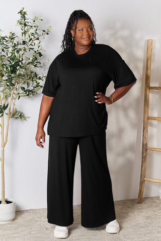 Woman wearing trendy black round neck slit top and pants set made of soft rayon-spandex blend, perfect for day to night fashion.