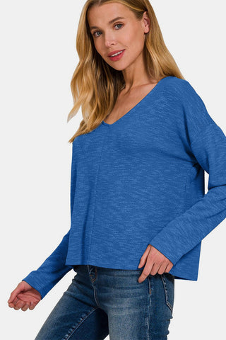 Woman wearing blue dropped shoulder long sleeve T-shirt with jeans, showcasing chic style and comfort for everyday wear.