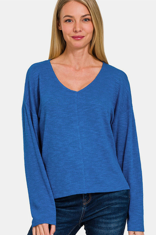 Woman wearing a blue dropped shoulder long sleeve t-shirt with a v-neck, showcasing its chic, versatile style and comfortable fit.