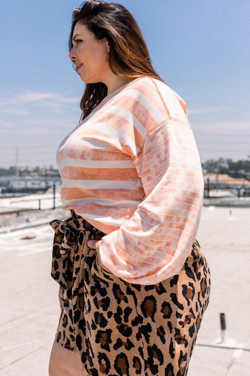 Woman wearing dusty pink striped French terry top with round neckline and contrast sleeves, paired with leopard print skirt.