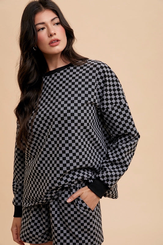 Woman wearing a black checkered round neck top and drawstring shorts set with pockets, featuring a basic style and slight stretch.