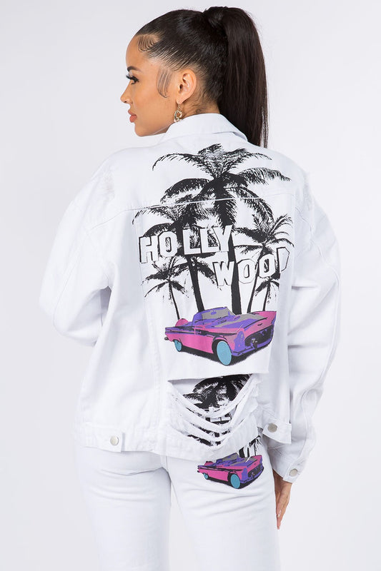 Woman wearing a white denim jacket with Hollywood palm tree and car graphic design, showcasing a trendy and edgy fashion look.