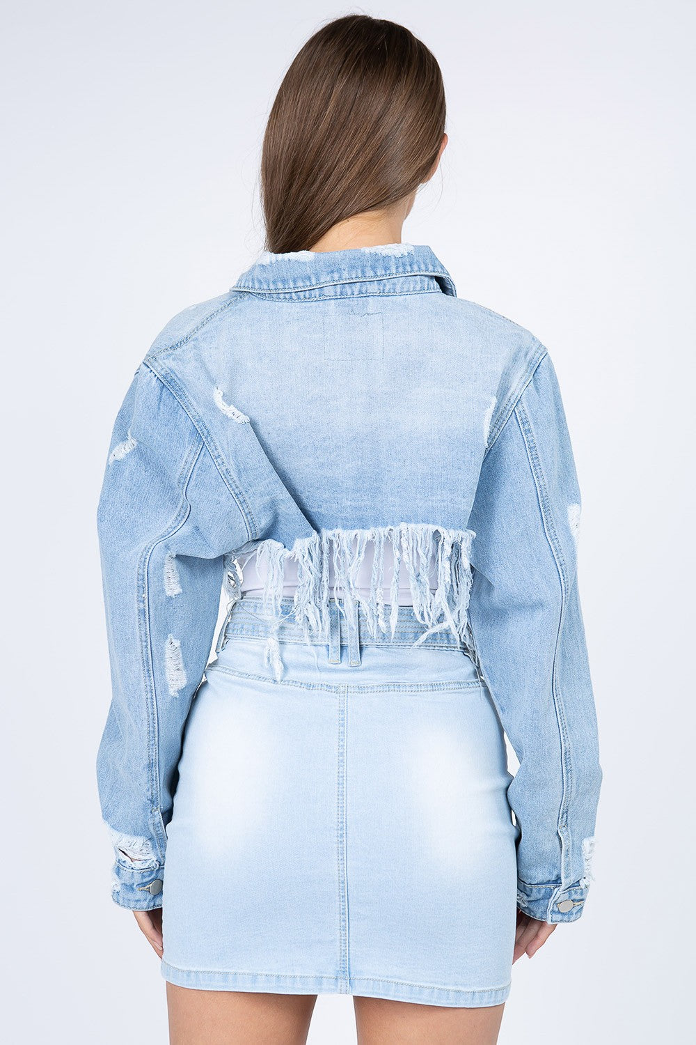 Distressed denim jacket with frayed hem, showcasing edgy style and vintage-inspired look, perfect for casual outings.