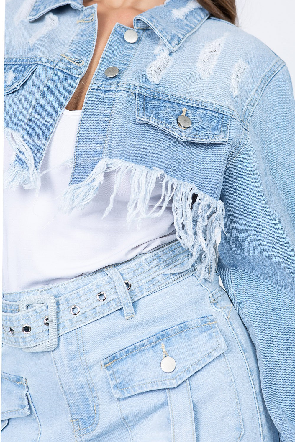 Distressed denim jacket with frayed hem and vintage button closure for an edgy, on-trend look.