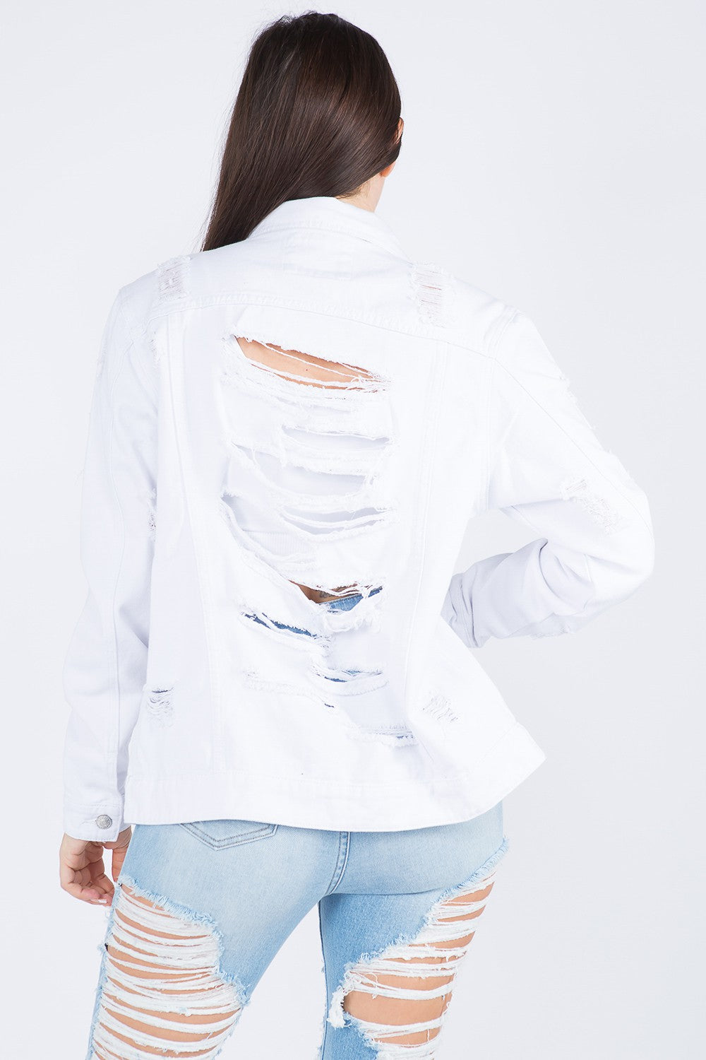 Distressed back detail on a white denim jacket, showcasing edgy style and trendy design.