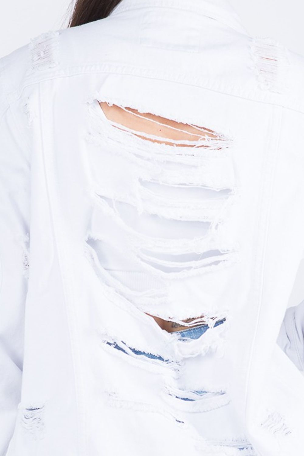 Distressed white denim jacket with back detailing showing ripped design for an edgy, fashionable look.