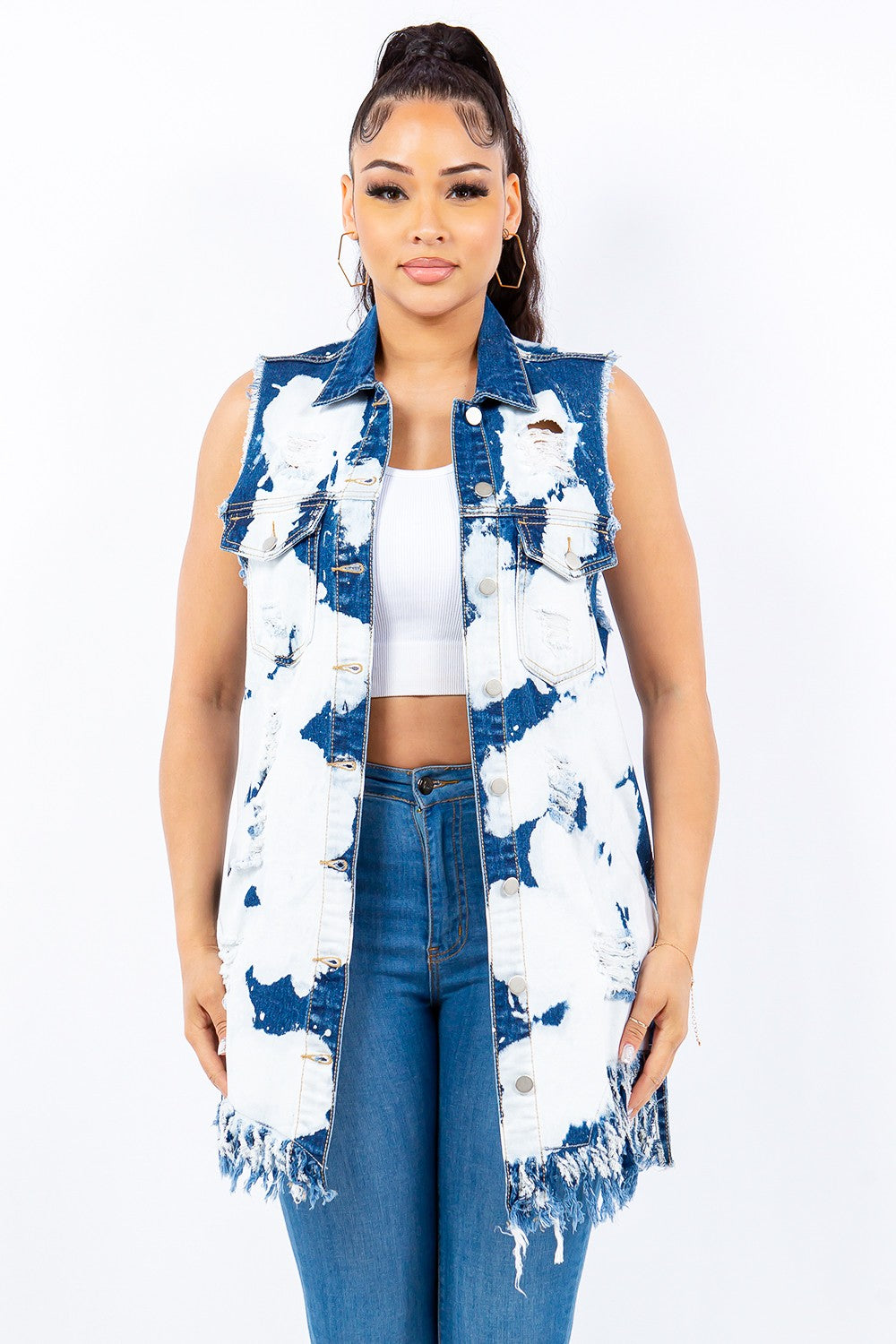 Woman wearing distressed frayed edge longline denim vest with a trendy raw hem and button front closure.