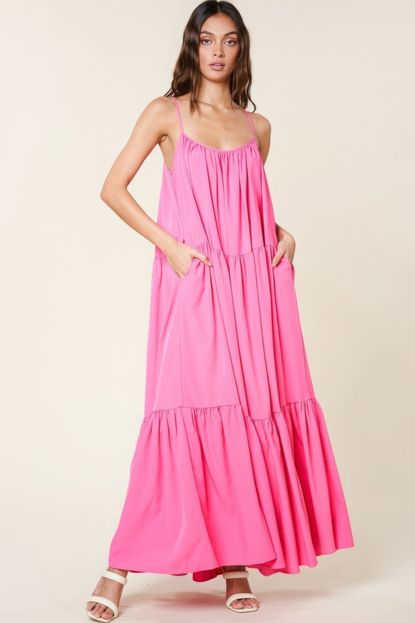 Woman wearing pink maxi sun dress with adjustable straps and pockets, perfect for summer occasions and casual outings.