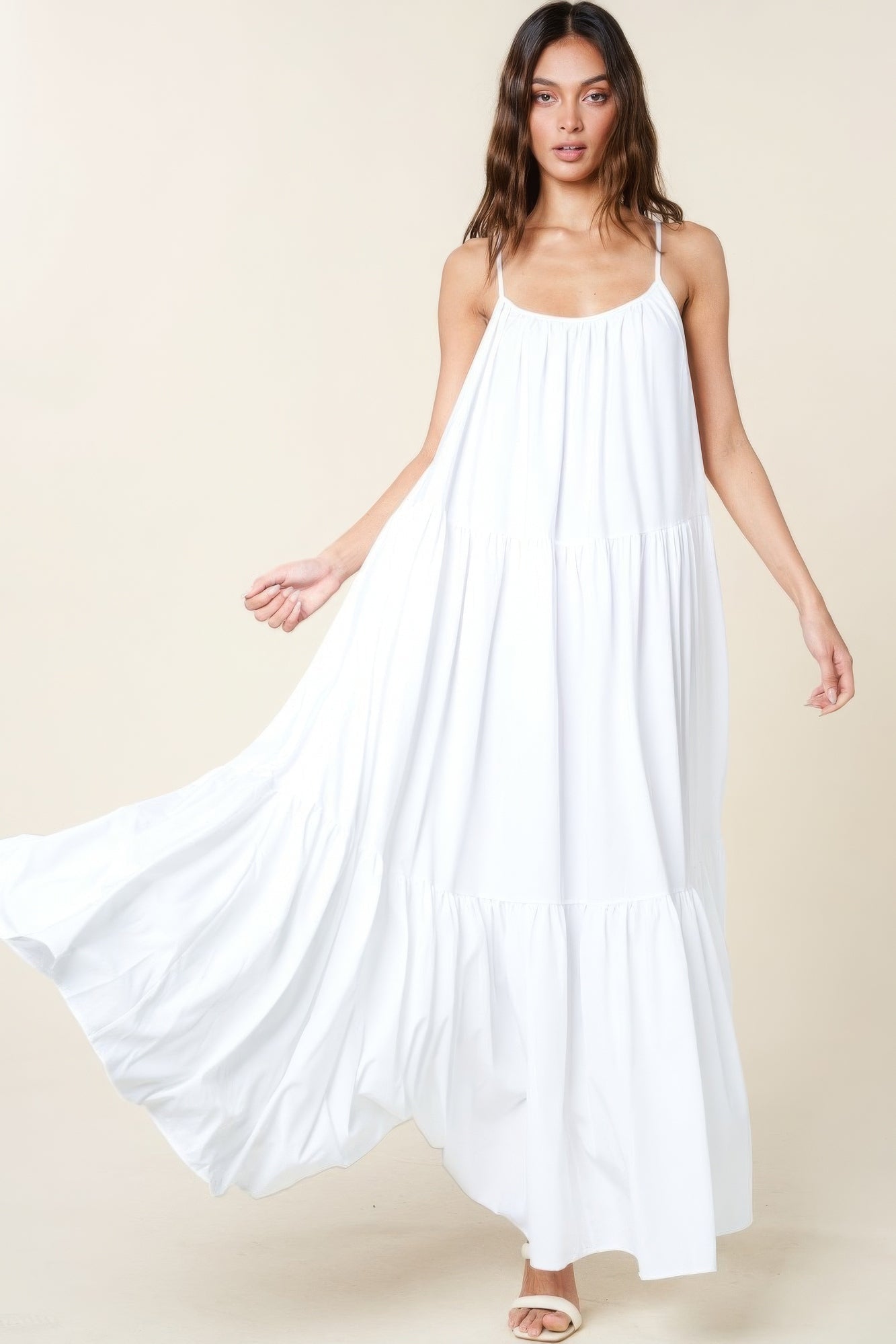 Woman wearing white maxi sun dress with adjustable straps and flowy A-line cut, perfect for summer occasions.