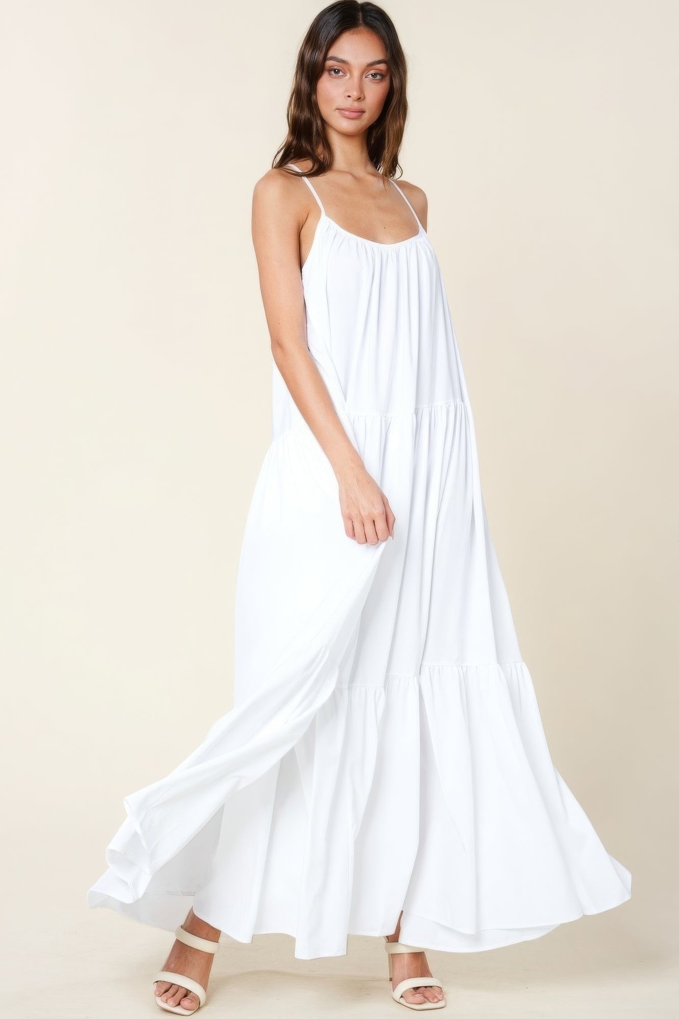 White maxi sun dress with adjustable straps and pockets, featuring a flowy A-line cut and perfect for summer occasions.