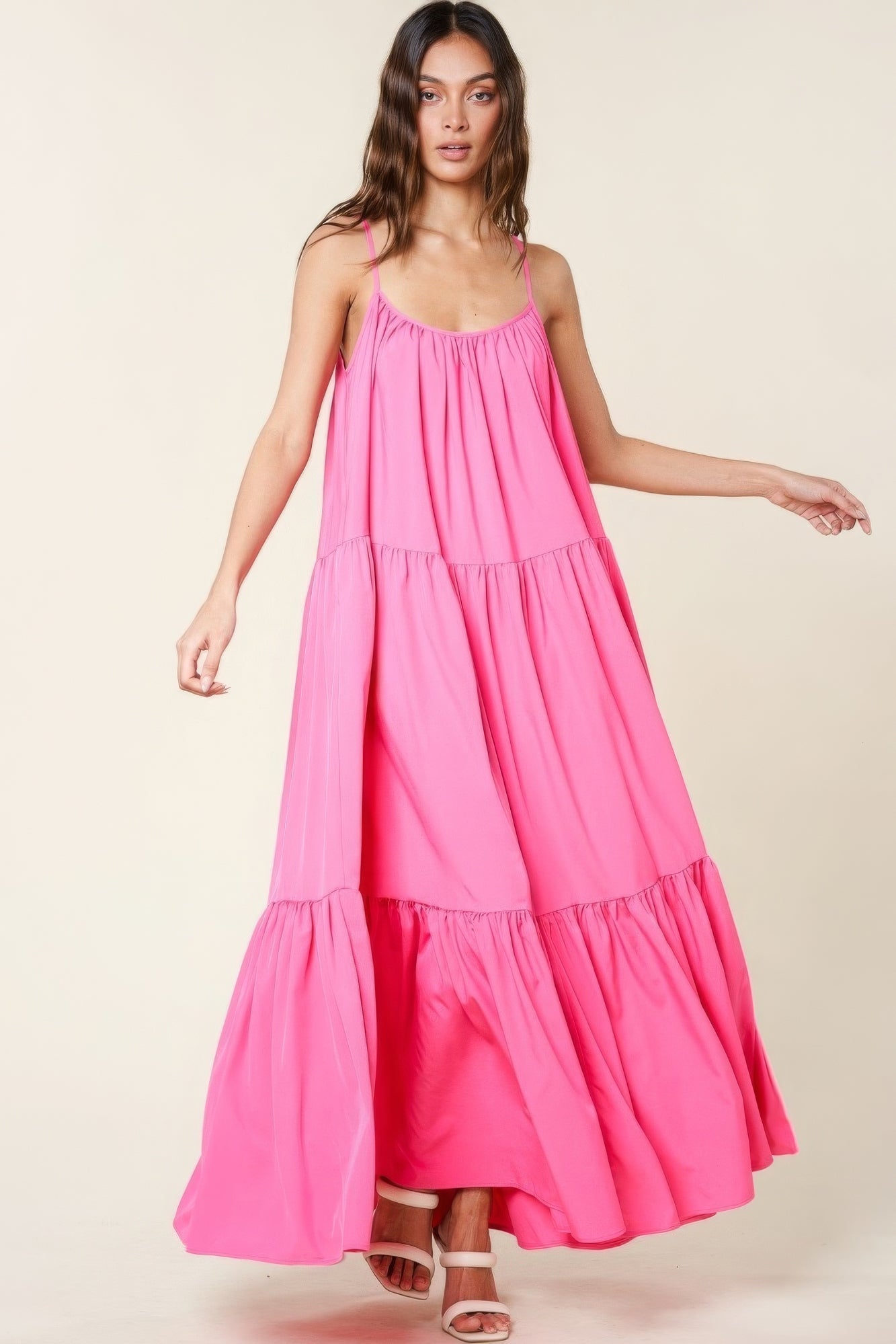 Woman wearing pink maxi sun dress with adjustable straps and pockets, showcasing flowy A-line fit and comfortable summer style.