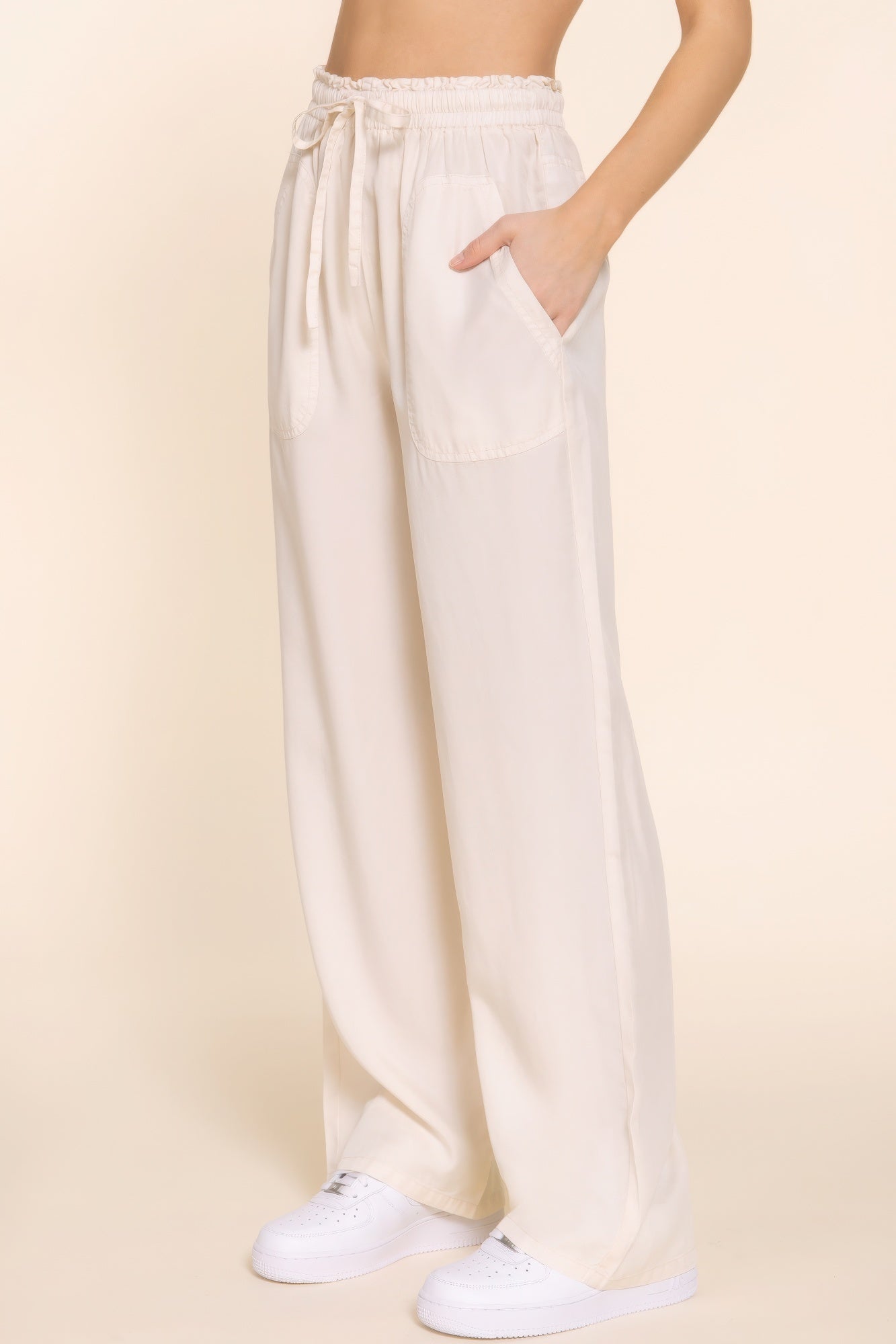 Woman wearing white elastic waist Tencel long pants with pockets and sneakers, showcasing a comfortable and stylish fit.