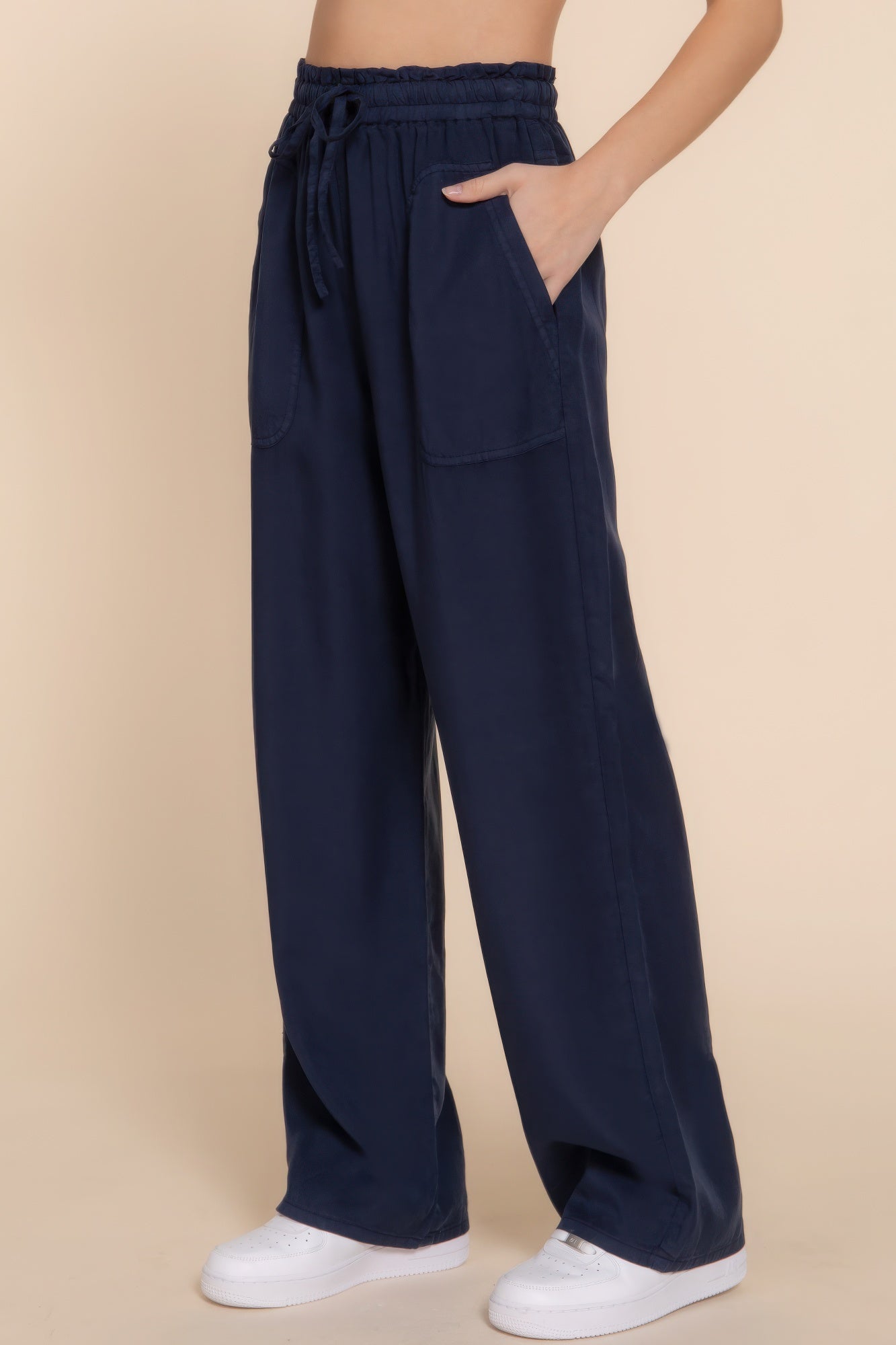 Navy Tencel long pants with elastic waist and pockets, styled with white sneakers for a casual look.