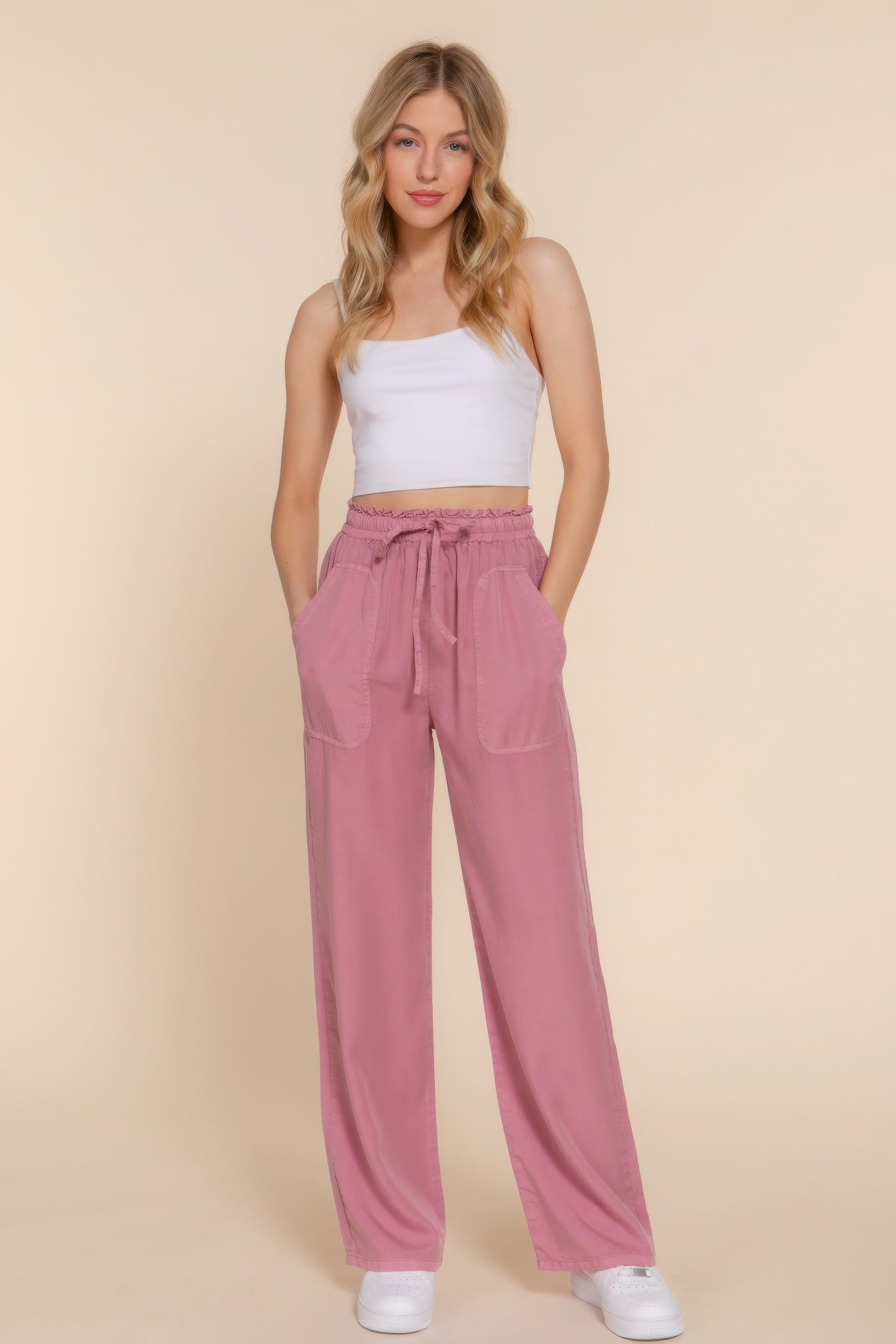 Woman wearing pink elastic waist Tencel long pants with a white top, showcasing versatile and comfortable everyday fashion.