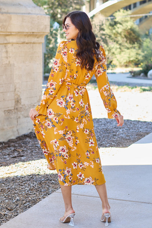 Woman wearing a yellow floral tie back flounce sleeve dress, walking outdoors, showcasing the back design and long sleeves.