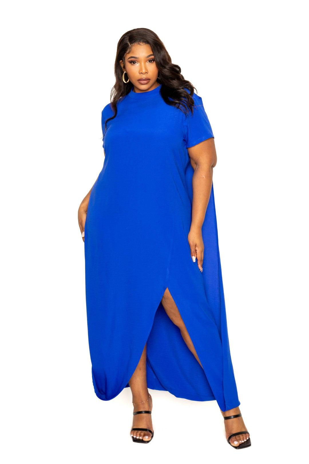 Woman wearing a royal blue mock neck back cape dress in plus size, showing a stylish slit and elegant design.