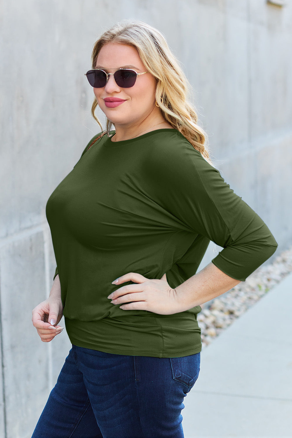 Woman wearing a green round neck batwing sleeve top with jeans, showcasing a basic style made of rayon and spandex.