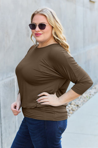 Stylish woman wearing a brown round neck batwing sleeve top with sunglasses, made of 95% rayon and 5% spandex, showcasing a chic look.