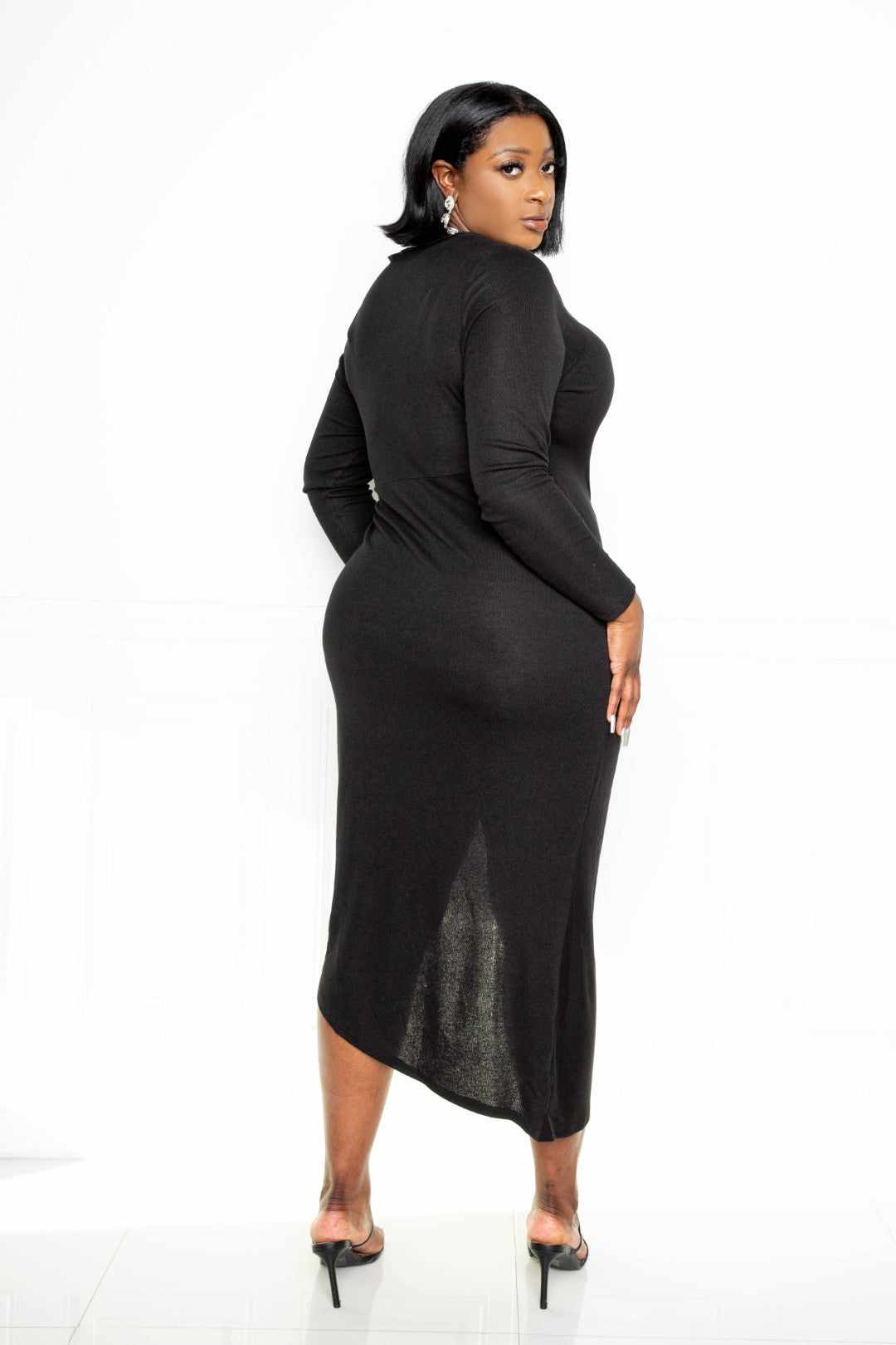 Black sweater dress with asymmetrical hem and waterfall ruffle, designed for comfort with polyester and spandex blend.