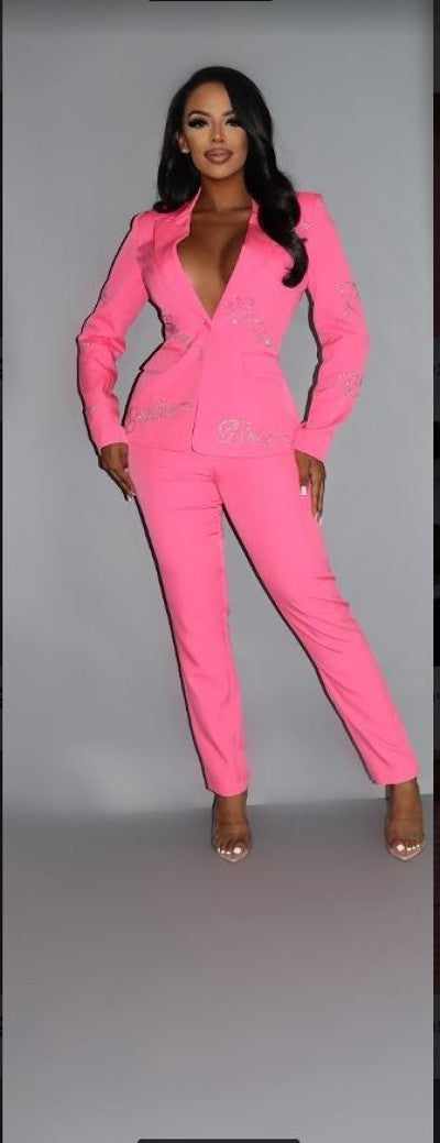 Woman wearing a pink two-piece power suit blazer with rhinestone lettering, showcasing a stylish and elegant design.