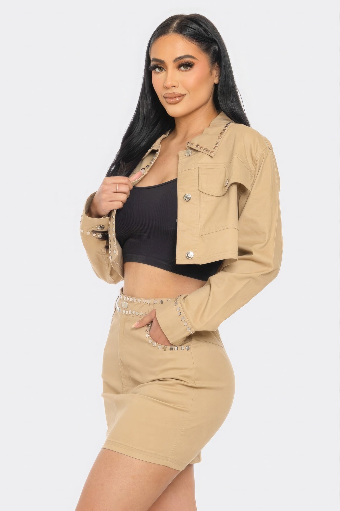 Woman wearing taupe embroidered cropped shirt set with flap chest pockets, showcasing stylish and playful design.